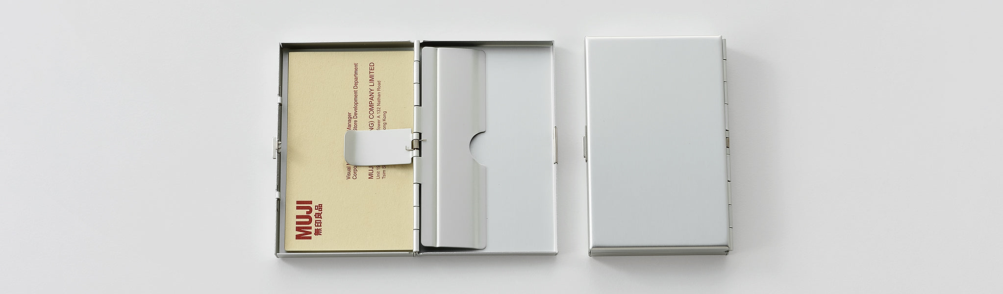 An open aluminum card holder next to a closed one