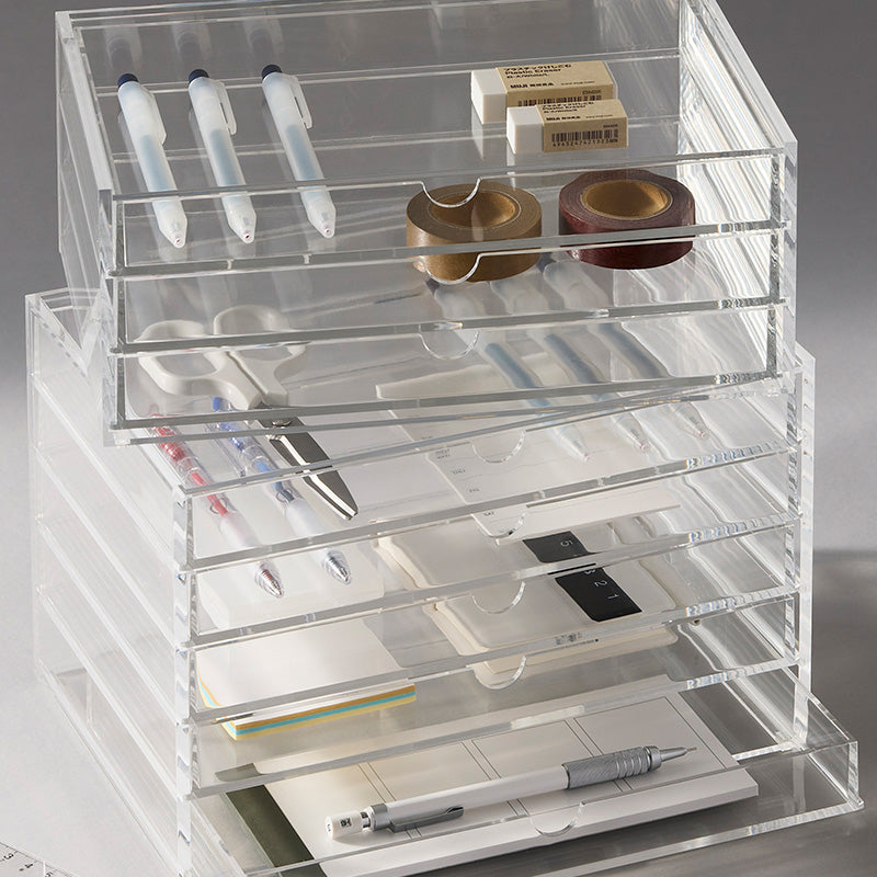 Clear acrylic desk organizer with multiple sliding drawers and top storage slots.