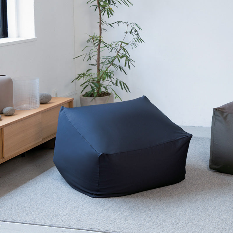 Body Fit Cushion in a modern living room with a plant and wooden shelf.