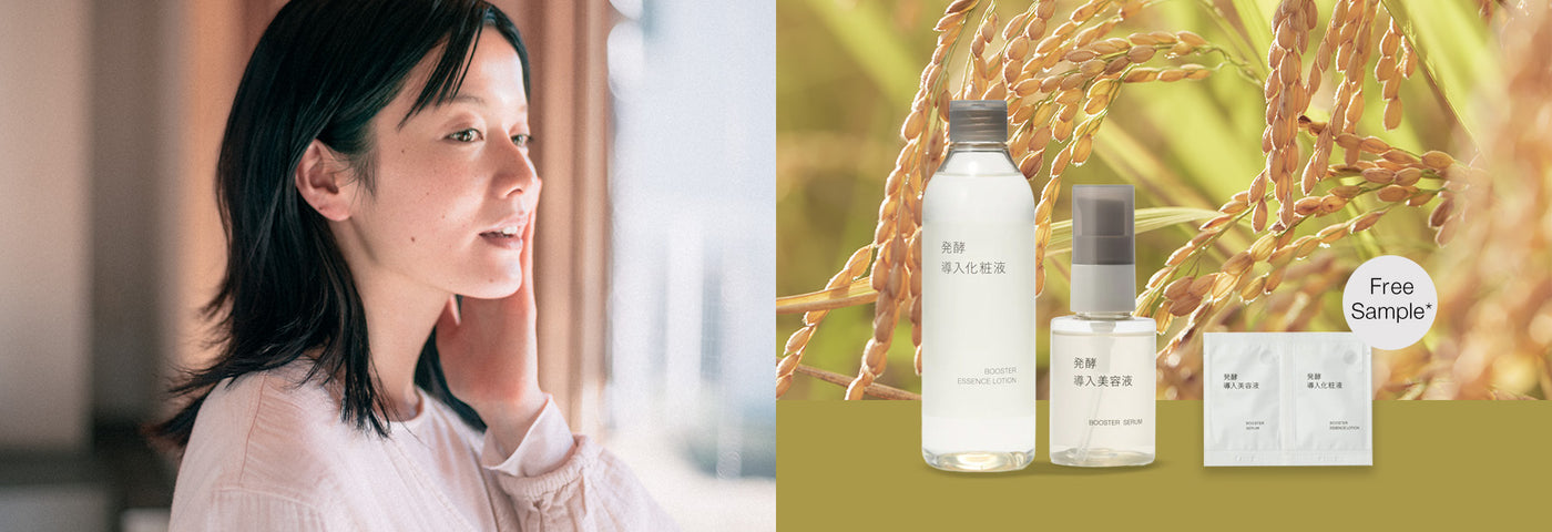 Woman looking out a window touching her skin; booster series