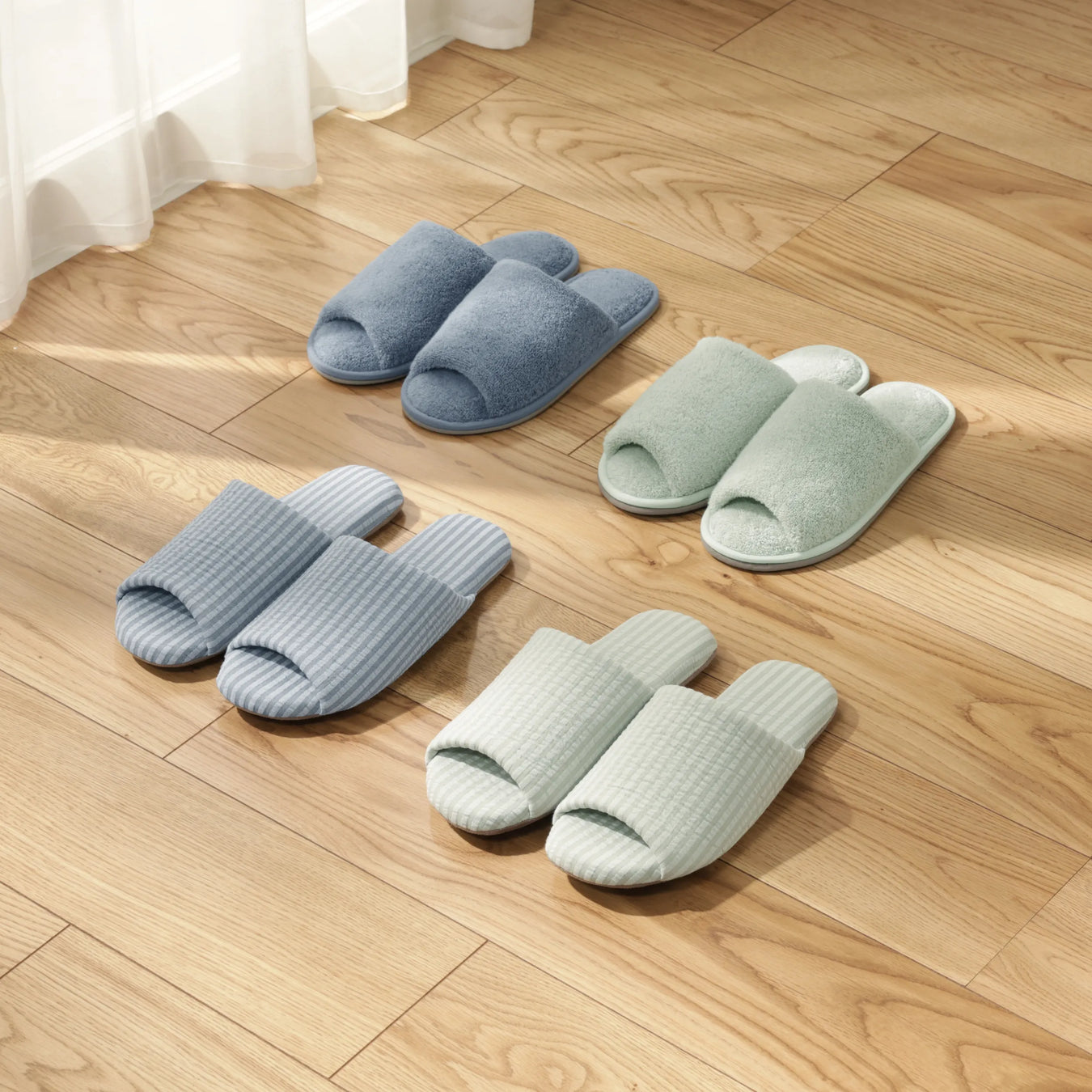 4 pairs of slippers on a wood floor. 