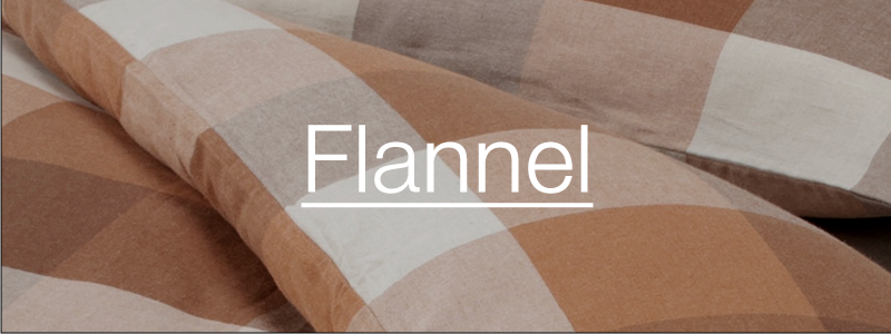 Close-up of a plaid flannel fabric in warm brown, beige, and off-white tones