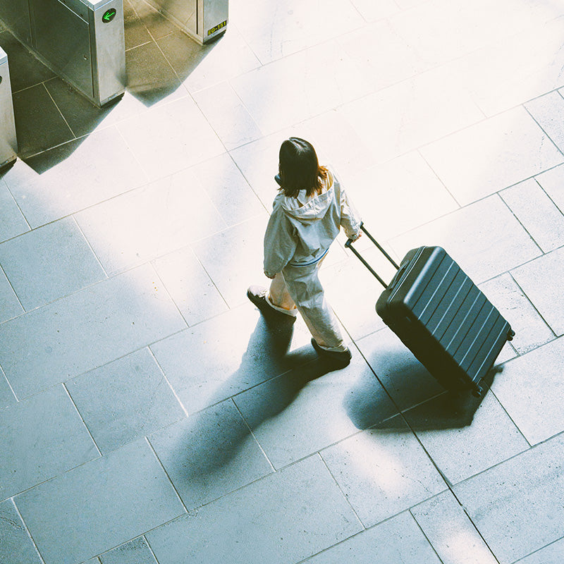 Woman walking with a MUJI Hard Shell Suitcase