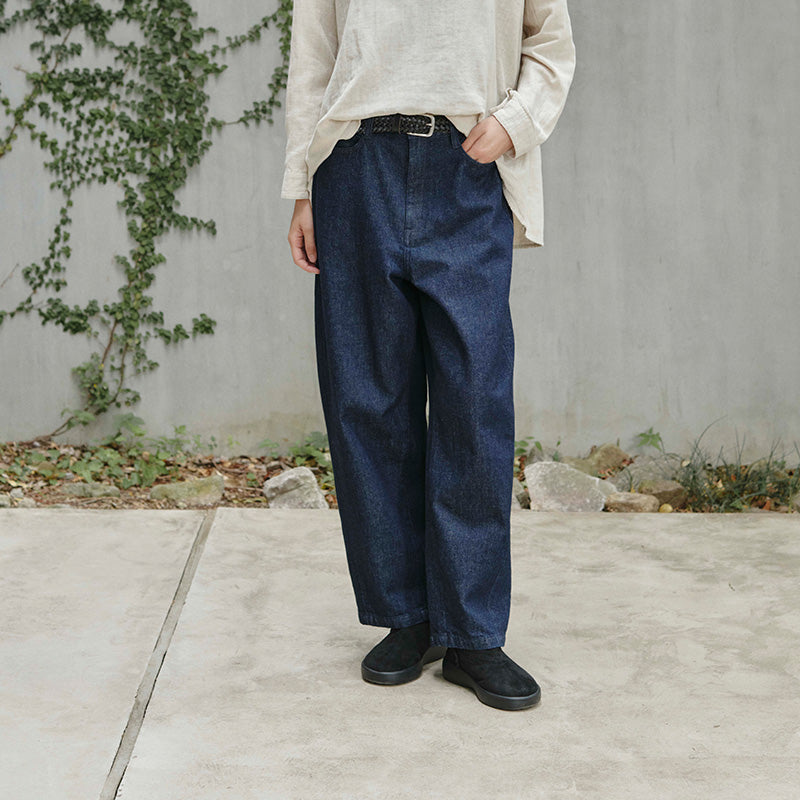 Women's denim pants. Loose fit, standing in a concrete setting.