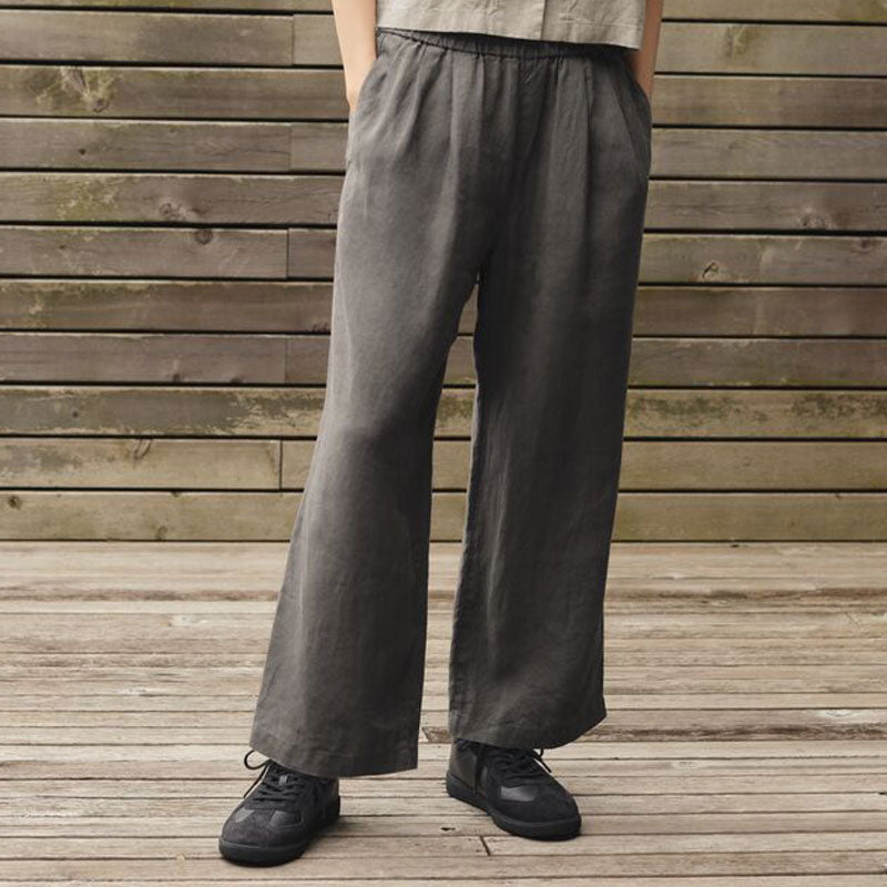 A person wearing dark gray wide-leg linen pants with an elastic drawstring waist