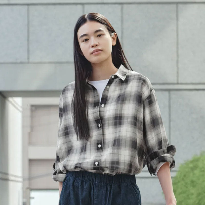 A woman wearing a black and white plaid button-down shirt
